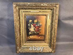 Old oil painting on wood, flower bouquet in wooden and plaster frame