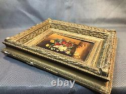 Old oil painting on wood, flower bouquet in wooden and plaster frame